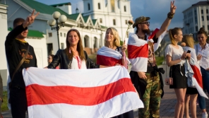 Demonstrující s běloruskou vlajkou. Zdroj: Paměť národa