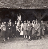 Zabijačka u pamětníkova dědečka Klementa Vítka (pátý zprava) ve Vlkoši. Hostem byl také Karel Engliš (pátý zleva) / 20. léta 20. století