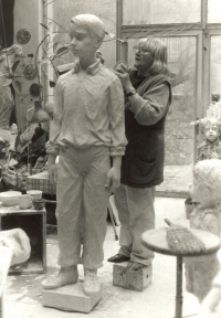 Marie Uchytilová na kostce retušuje sochu chlapce, poslední sochu sousoší lidických dětí (březen 1989)