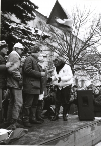 Monika Brázdová na fotografii druhá zprava vystupuje na pódiu s dalšími studenty na demonstraci na Horním náměstí v Humpolci v den generální stávky 27. listopadu 1989