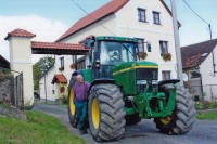 Jan Kreysa s traktorem před rodovým statkem