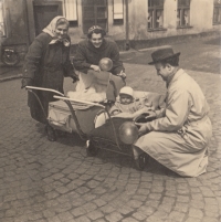 Stanislav Duchek v sesličce, v hlubokém kočárku jeho sestra. Zleva babička, maminka a tatínek.
