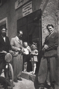 Vpravo strýc Jan Urban před obchodem se smíšeným zbožím (název obchodu uveden  česky a německy)