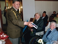 Otec Jaroslava Moravce Josef (vlevo na vozíku, vedle manželka) přebírá vojenské vyznamenání u příležitosti oslavy stých narozenin