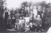 Manžel pamětnice na dobové fotografii žáků obecné školy (drží tabulku s letopočtem), Broumova Lhota, 1933-1934