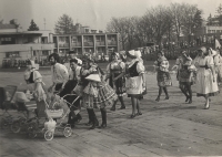 Baráčníci v krojích v prvomájovém průvodu na stadionu v Jaroměři v roce 1980, pamětnice v kroji druhá zpředu