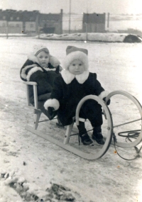 Únor 1944 v Praze, cesta do protileteckého krytu. Eva Kopejsková je první dítě na saních 