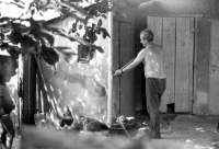 Erhard Pluške na dvoře svého domu drtí kosti slepicím