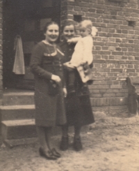 Hana in her mother's arms together with her aunt in front of the family house in Czermin, 1941
