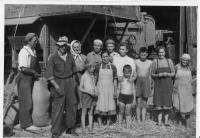 Family with farm hands at the estate, by the thresher - around 1947 (Zbyněk Bezděk is first from the left)