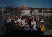 Celá rodina na oslavě sedmdesátin pamětnice - fotografováno na cestě ke svatému Antonínku, pamětnice ve fialovém sáčku; Blatnice; 1998