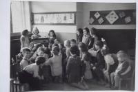 Ve školce ve skupině dětí (vzadu s pohledem do fotoaparátu)